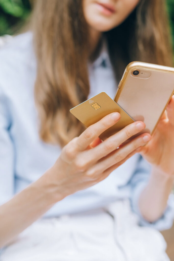 A symbolic display of Showit eCommerce - a girl holing a credit card and phone